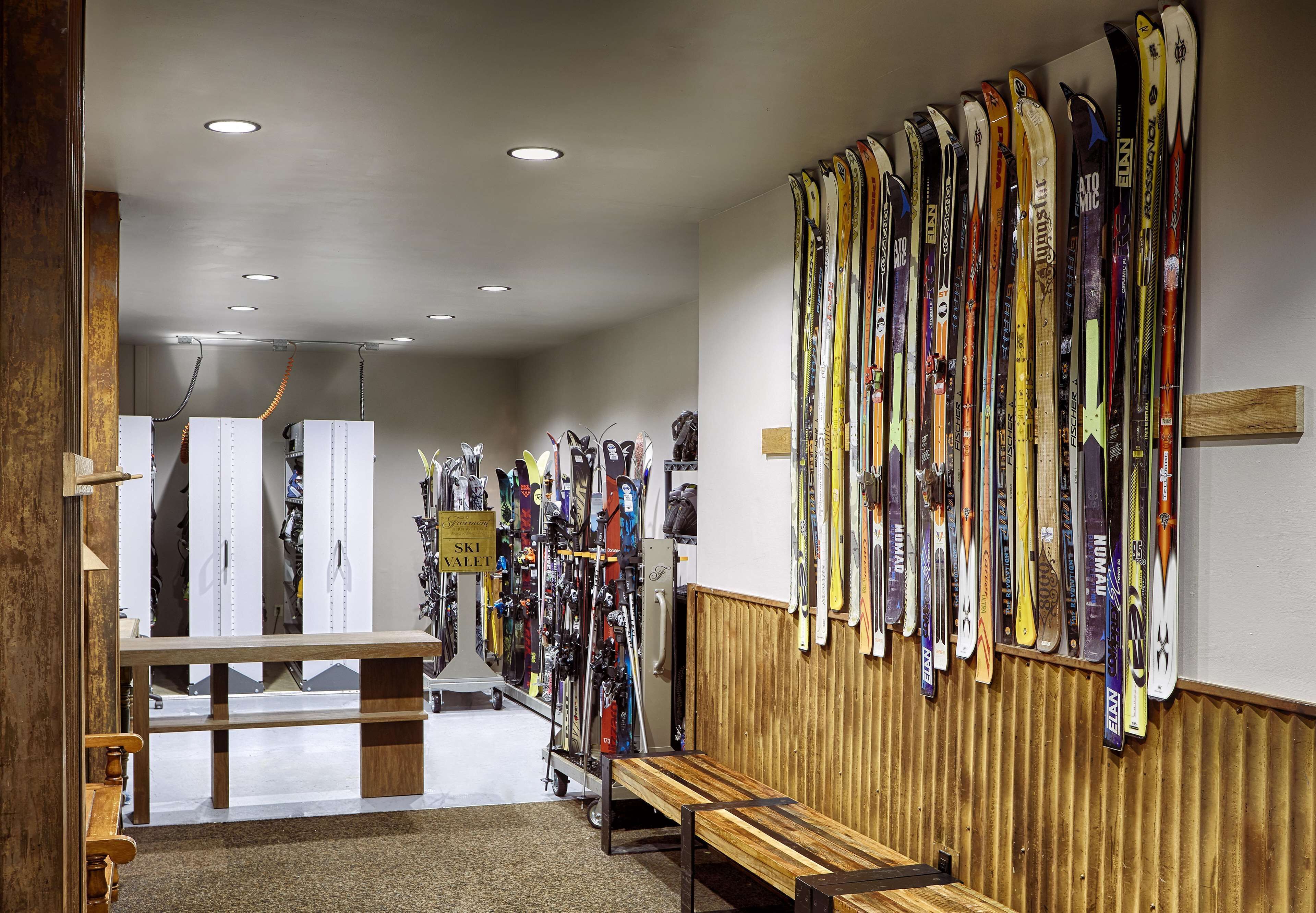 Een gebied voor het verhuren van ski's, met bankjes en een muur vol ski's.