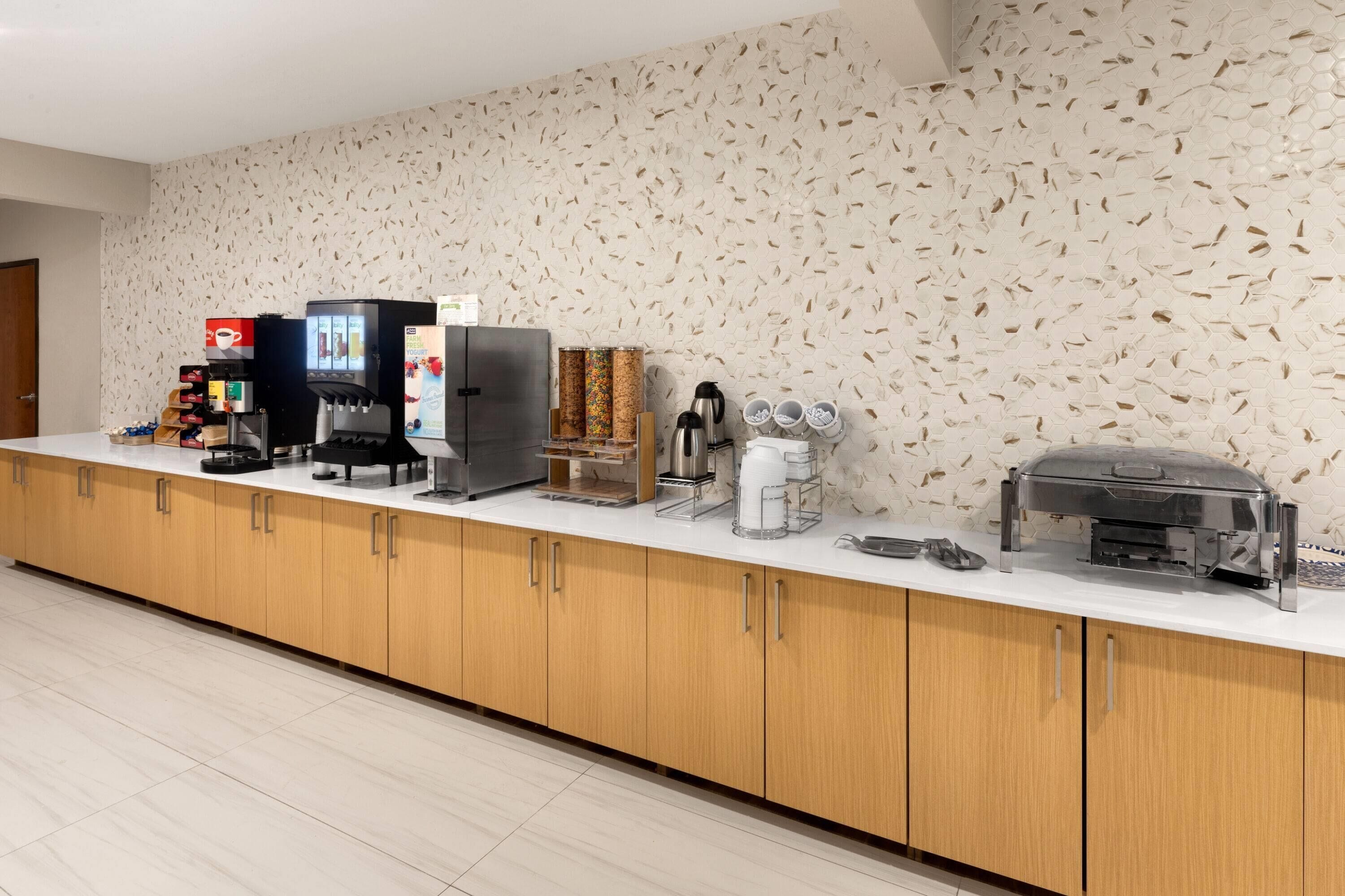 A modern kitchen area with a coffee station, a refrigerator, and a toaster.