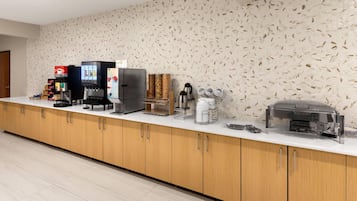 A modern kitchen area with a coffee station, a refrigerator, and a toaster.