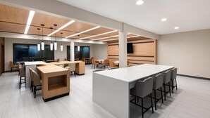 A modern conference room with a central island, multiple tables, and chairs. - Hawthorn Extended Stay by Wyndham College Station South (College Station)