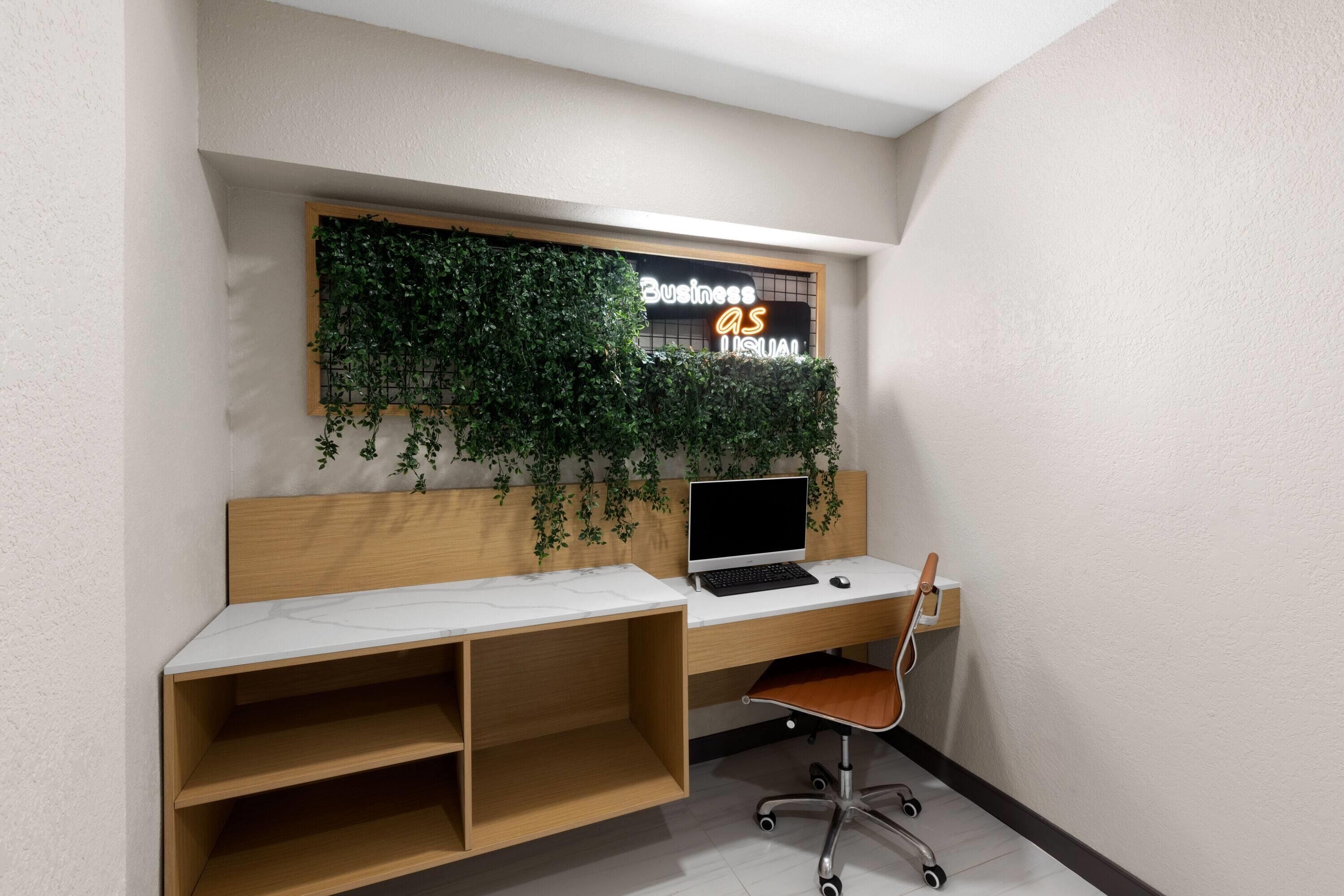 Un espacio de oficina moderno con un escritorio de madera, una computadora portátil y una silla.