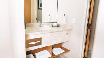 A bathroom with a sink, mirror, towel rack, and wooden shelves.