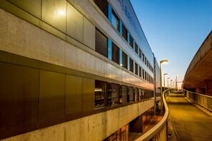 A modern building with a curved facade, large windows, and a covered walkway.
