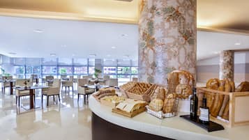 Un moderno vestíbulo de hotel con un mostrador de recepción curvo, zona de estar y grandes ventanales que ofrecen vistas al exterior.