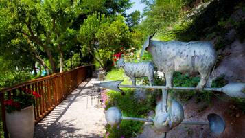 Un sentier de jardin agrémenté d’une sculpture métallique décorative représentant une vache et des flèches.