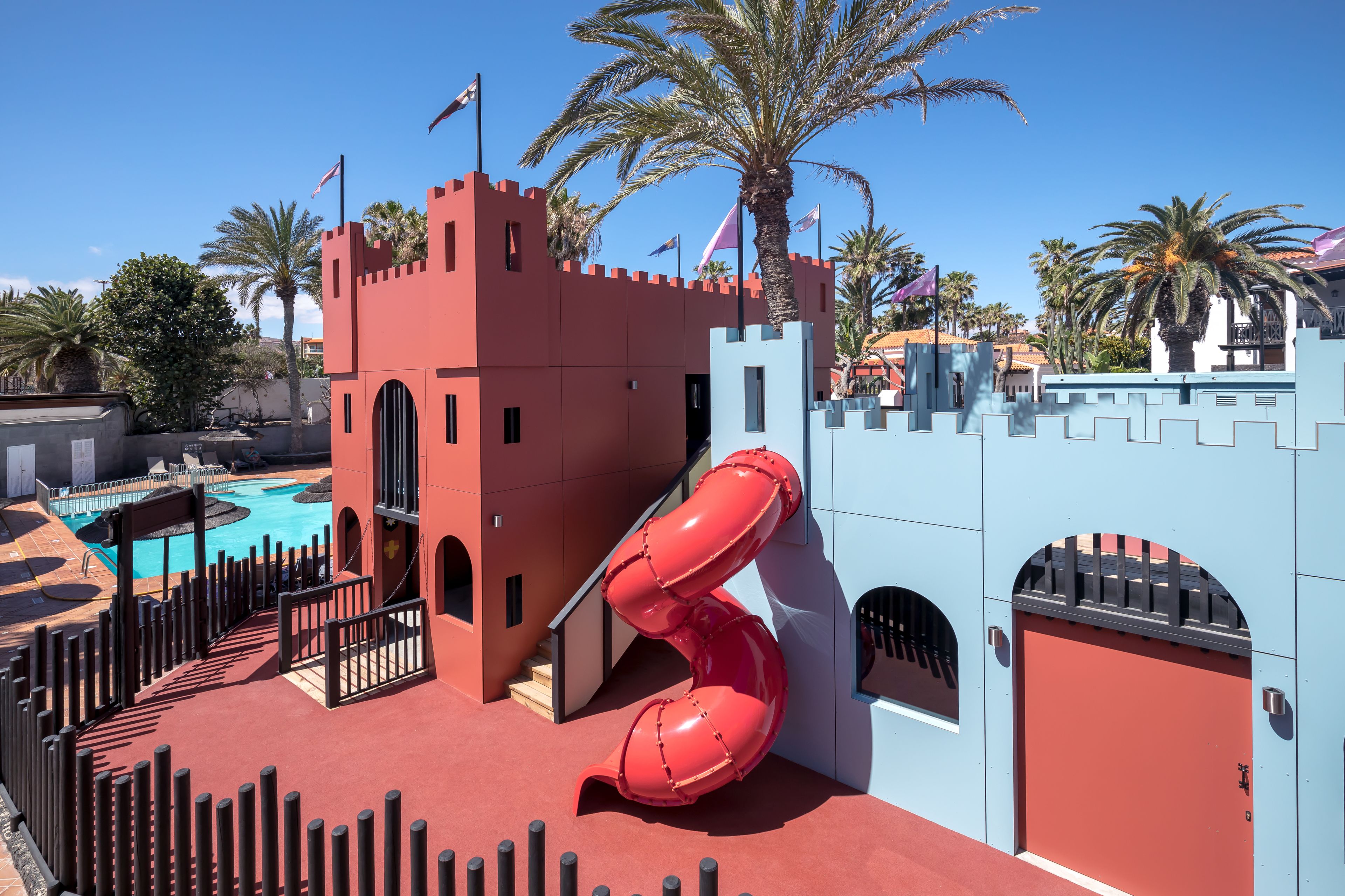 A castle-themed play area with a slide, pool, and red and blue walls.