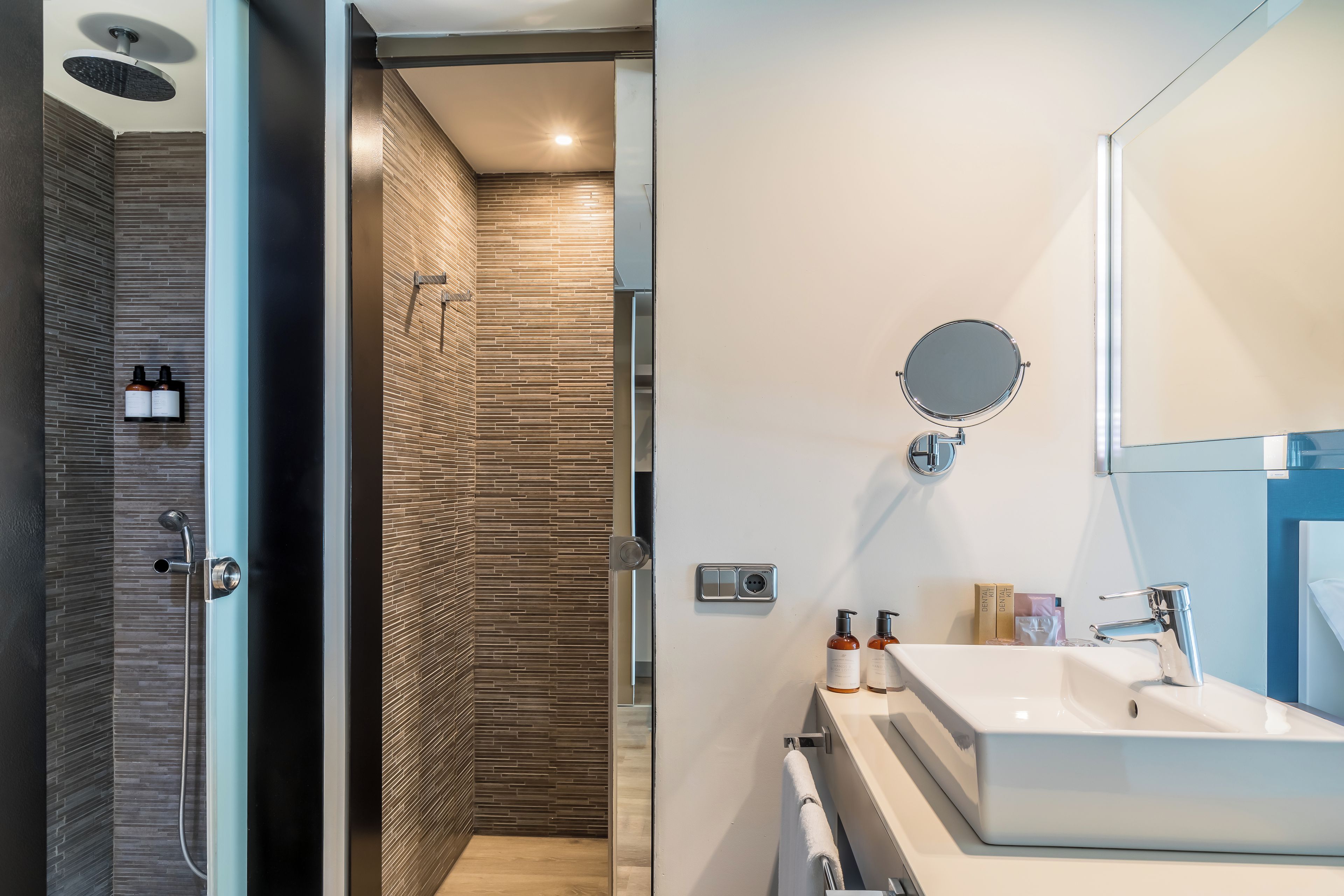A modern bathroom with a shower, a sink, and a mirror.