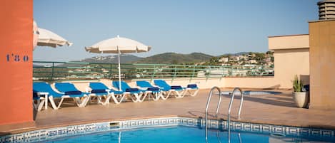 Piscina a l'aire lliure, para-sols i gandules