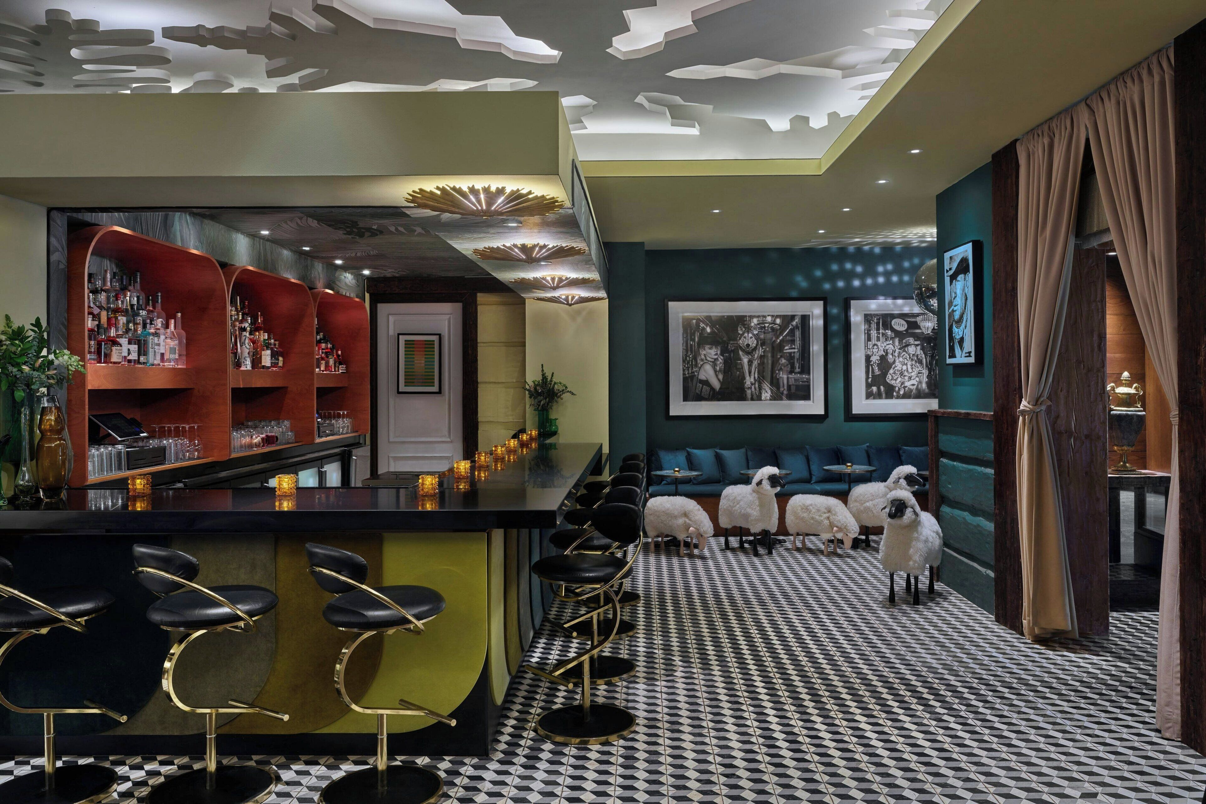 A bar area with stools, a shelf with bottles, and a patterned floor.