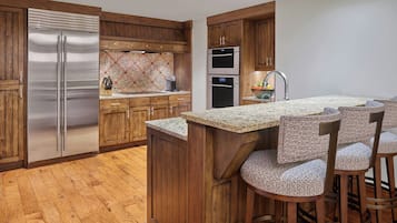 A modern kitchen with wooden cabinets, stainless steel appliances, and a granite countertop.