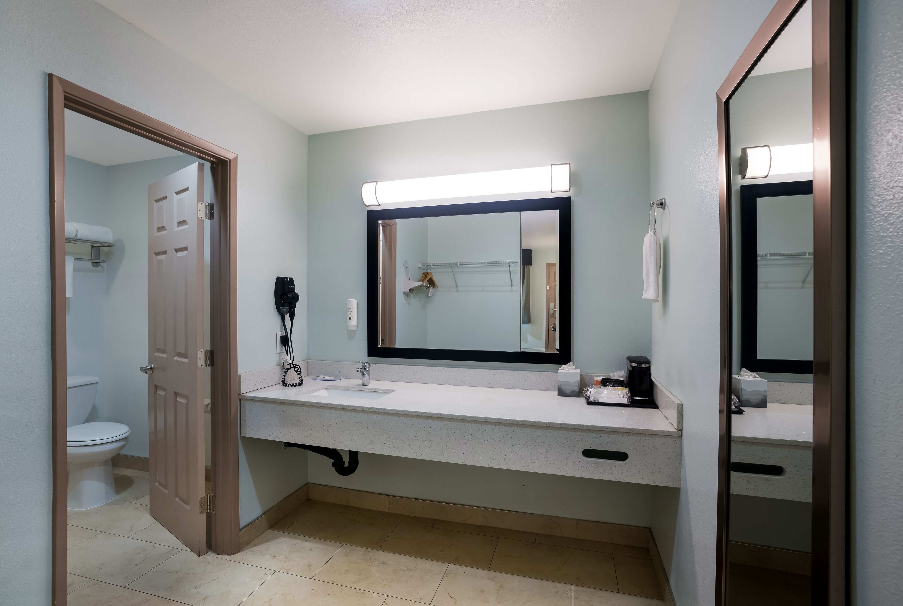 A bathroom with a white sink, a mirror, and a toilet.