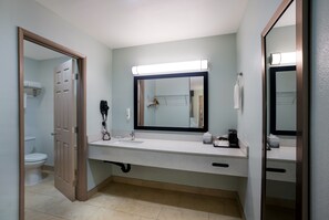 A bathroom with a white sink, a mirror, and a toilet. - Quality Inn Fairfield Napa Valley Area (Fairfield)