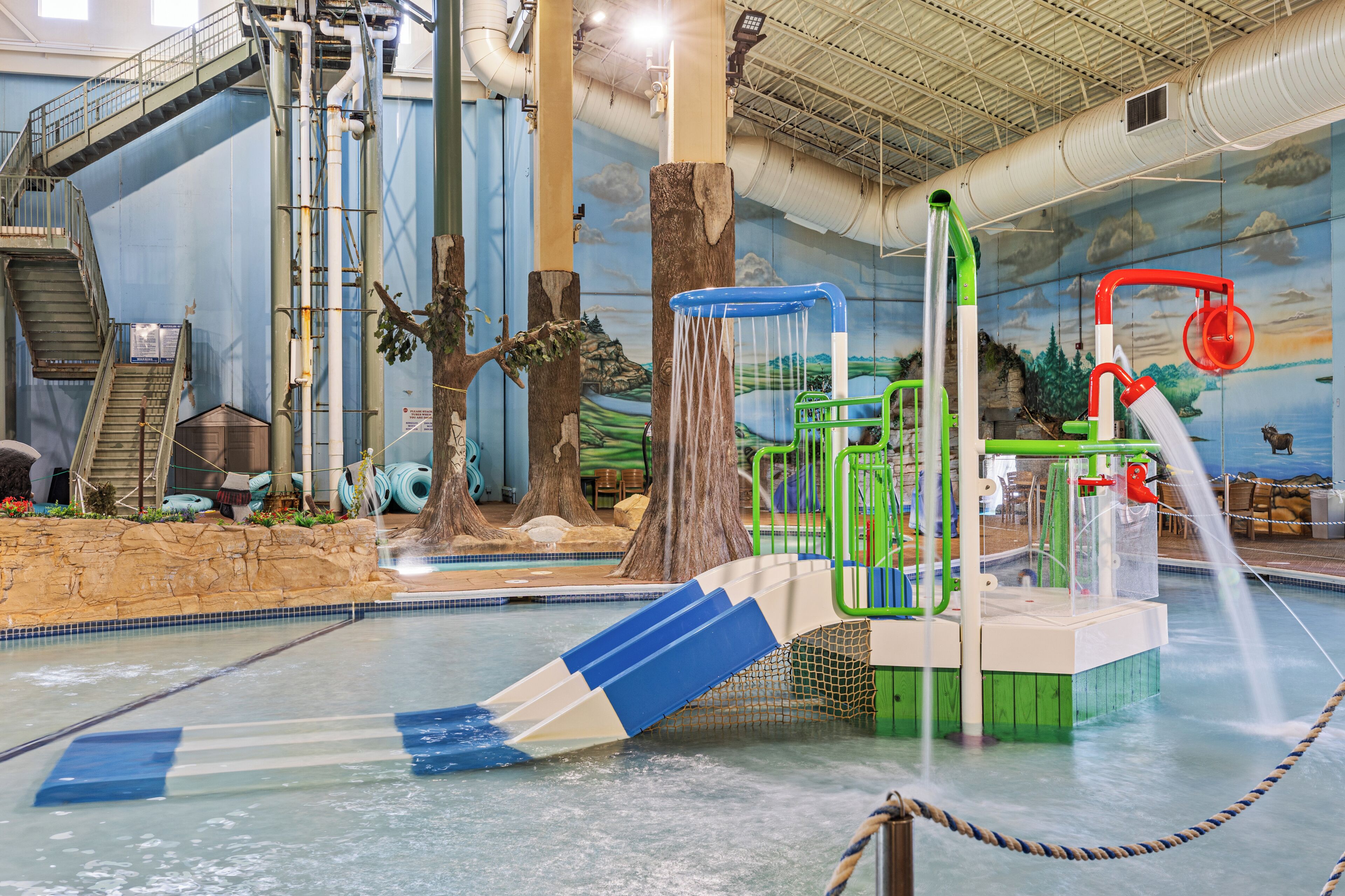 An indoor water park with slides, a climbing area, and a pool.