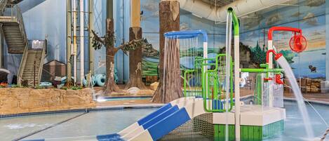 Parque acuático interior con toboganes, zona de escalada y piscina.