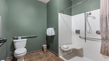 A bathroom with a toilet, shower, and grab bar.