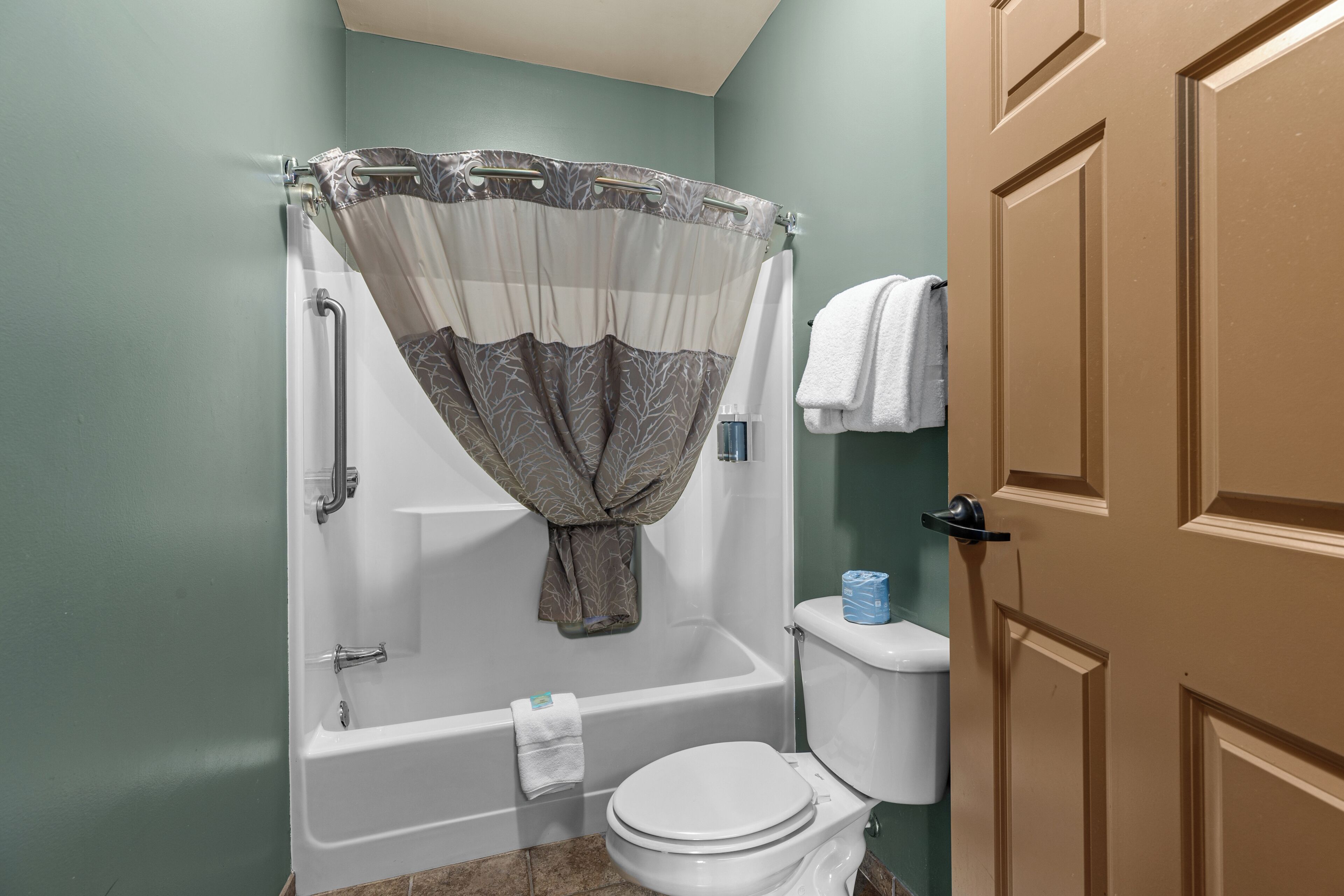 Un baño con bañera, inodoro y cortina de ducha.