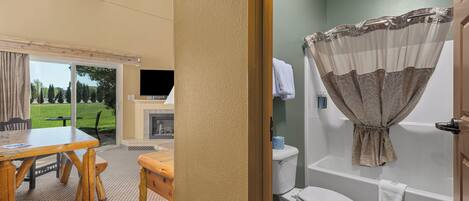 A bathroom with a toilet, bathtub, and shower curtain.