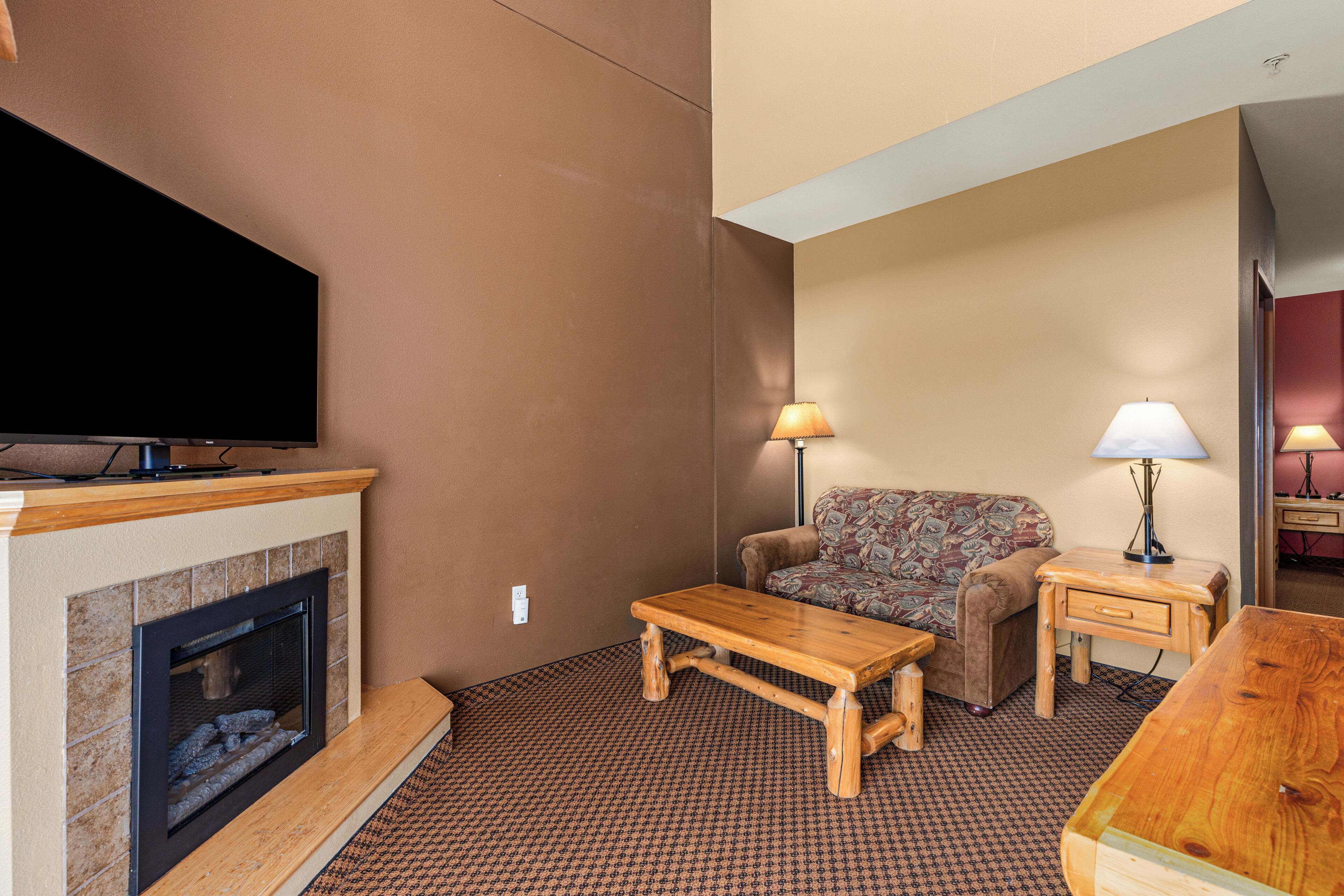 A living room with a fireplace, a television, a sofa, and a coffee table.