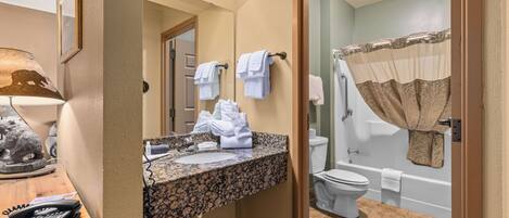 A bathroom with a sink, toilet, and bathtub.