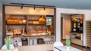 A modern breakfast bar with a variety of food items and a coffee machine. - B&B Hotel Hannover-Lahe (Hannover)