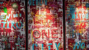 A wall with various words and phrases in different fonts and colors, including "BERLIN," "ONE," and "CITY."