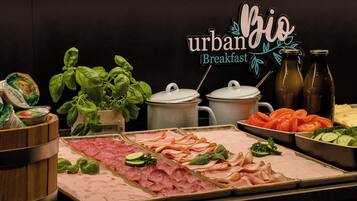 A breakfast buffet with various meats, vegetables, and a sign reading "urban breakfast".