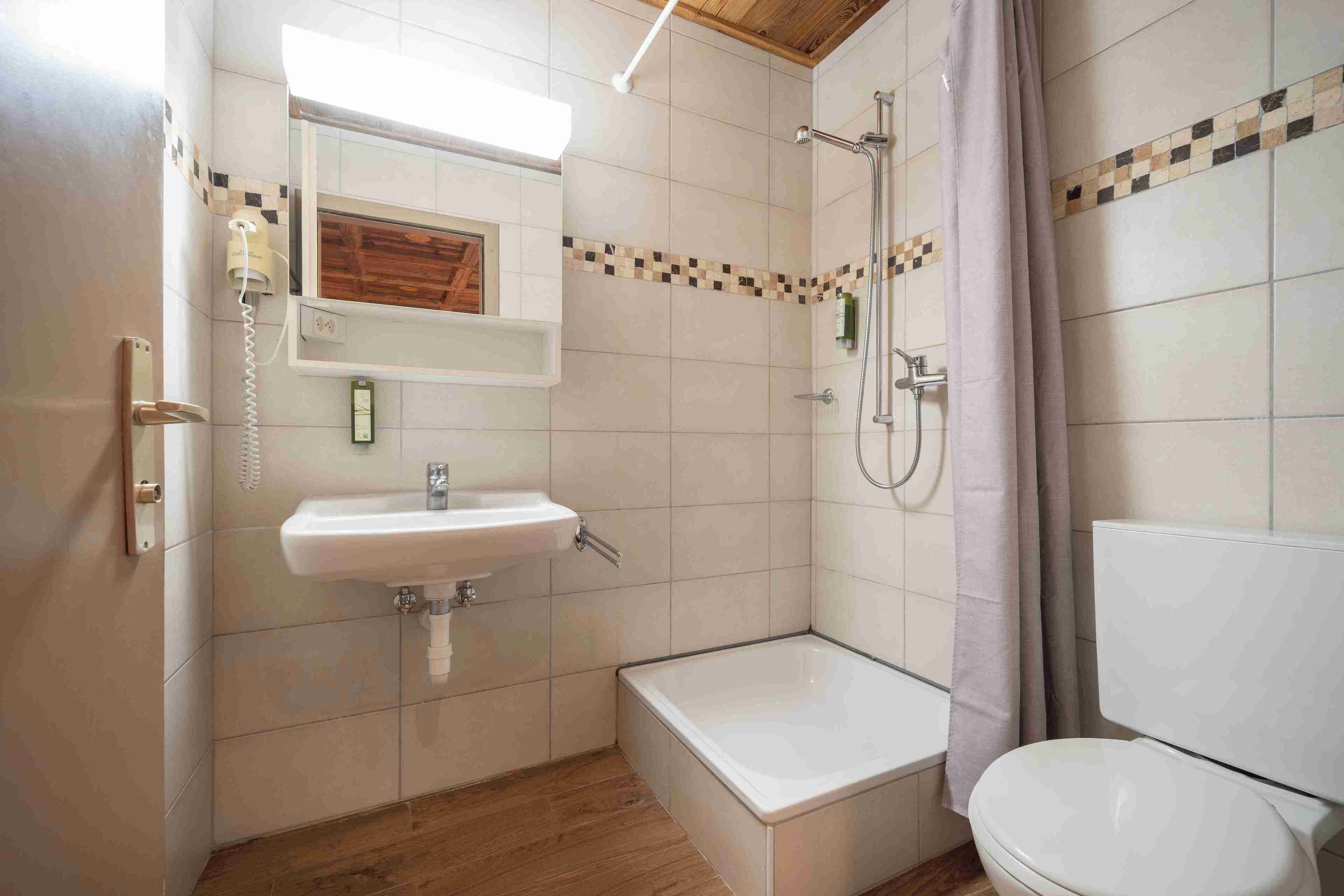 Un baño con lavabo, espejo, ducha e inodoro.