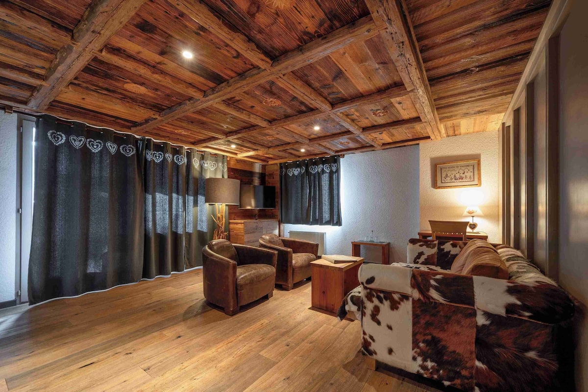 Un interior rústico con vigas de madera, sofás de cuero y una chimenea acogedora.