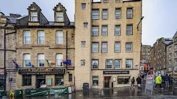 Un edificio histórico de varios pisos, con un pub llamado 'Biddy Mulligans' en la planta baja y 'The Grassmarket Hotel' al otro lado de la calle.