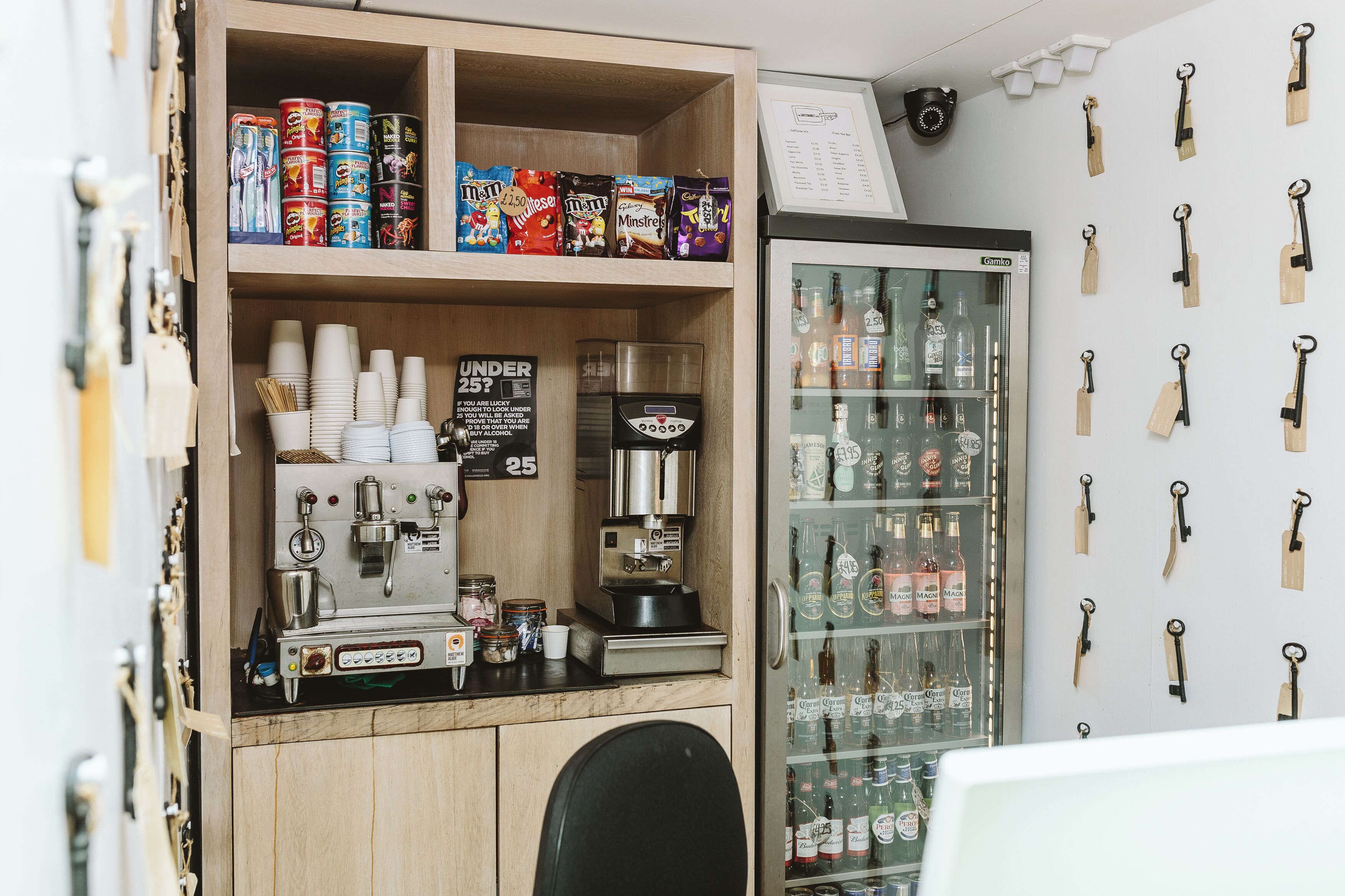 A coffee shop counter with a coffee machine, cups, and snacks.