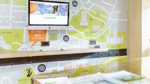 A reception desk with a map and a monitor displaying a map. - Grassmarket hotel (Edinburgh)