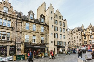 A historic building with multiple stories, featuring a pub named 'Biddy Mullegans' and a hotel named 'The Grassmarket'.