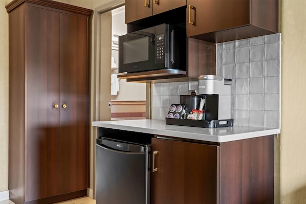 A compact kitchen with a built-in microwave, coffee maker, and dishwasher.