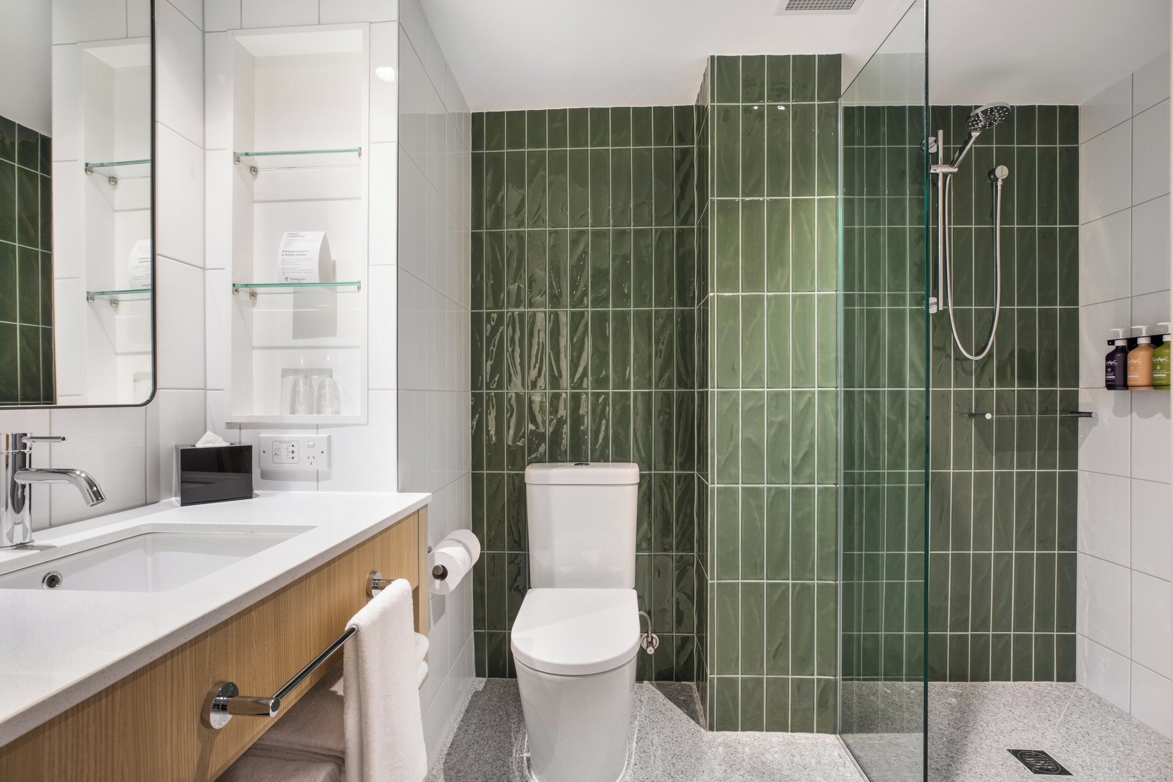 A modern bathroom with a glass-enclosed shower, a white sink, and a toilet.