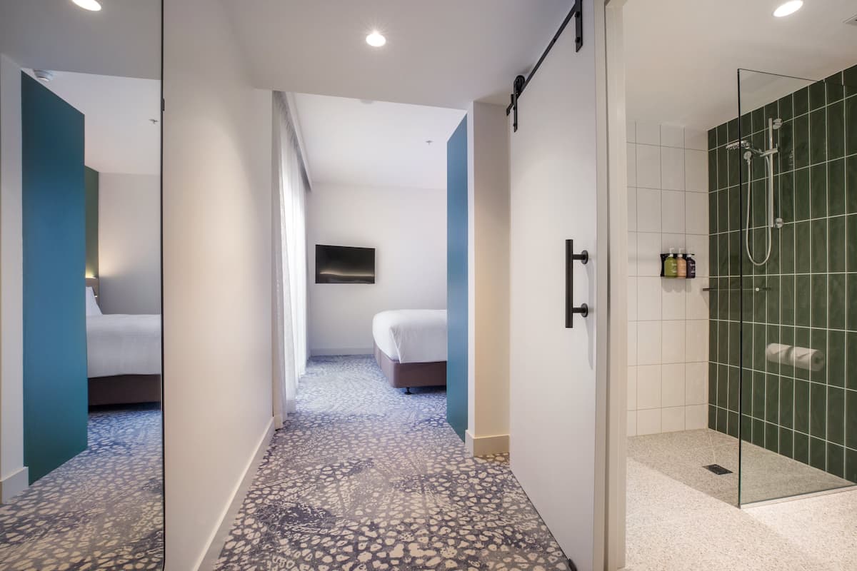 Une chambre d’hôtel avec une douche, un lit et une télévision.