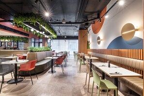A modern restaurant interior with seating arrangements, a bar area, and decorative wall elements. - Holiday Inn Dandenong by IHG (Dandenong)