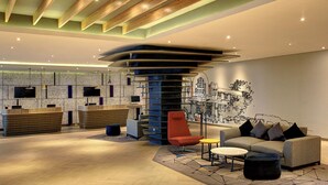 A modern lobby with a reception desk, seating area, and a large wall mural. - Novotel Jakarta Mangga Dua Square Hotel (Jakarta)