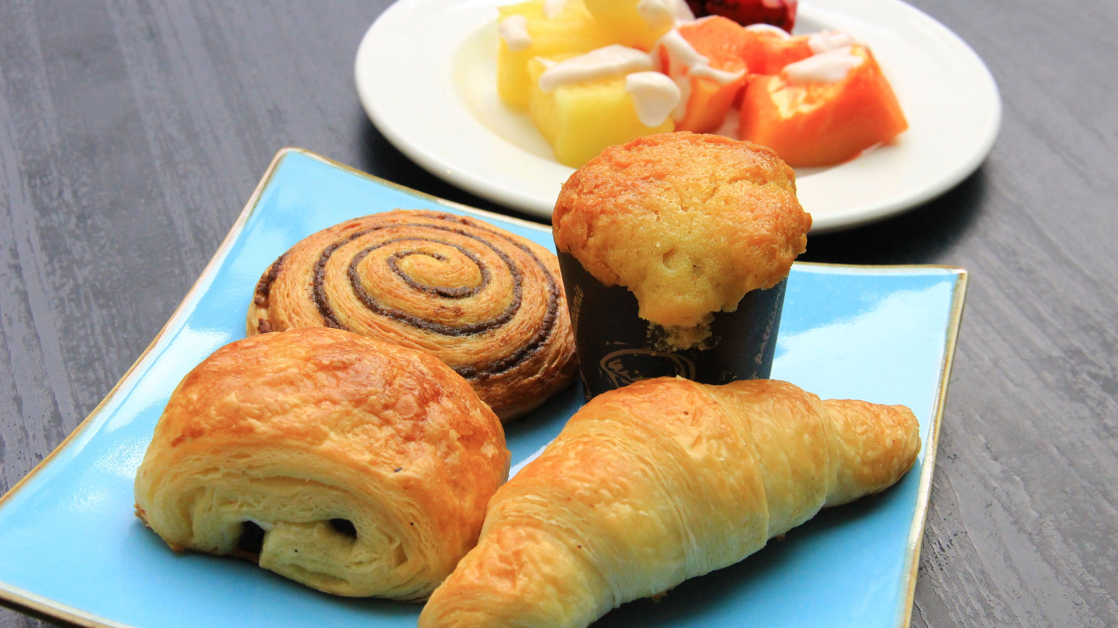 A plate with pastries and a plate of fruit.