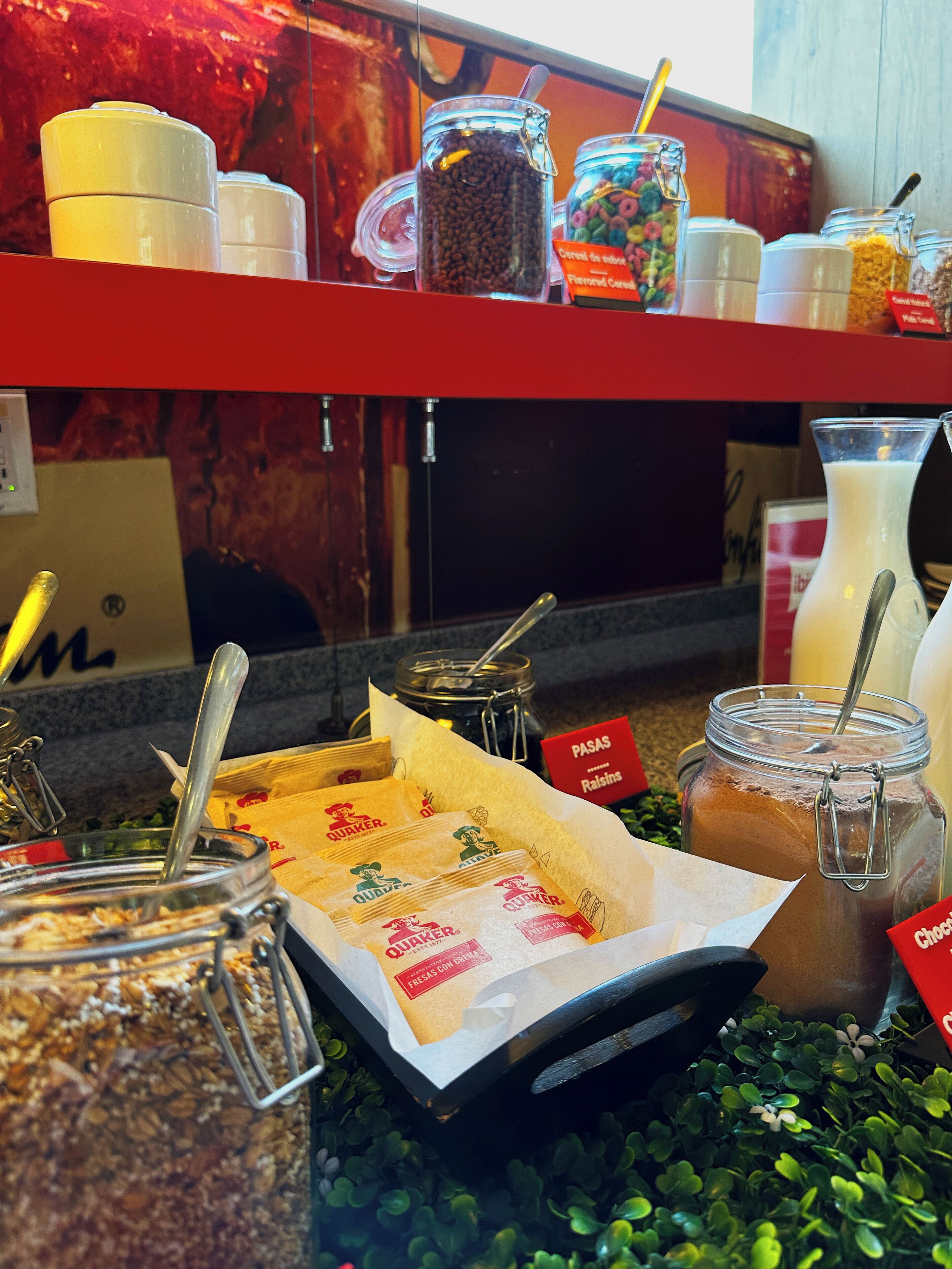 A self-serve coffee station with various coffee beans, pastries, and condiments.