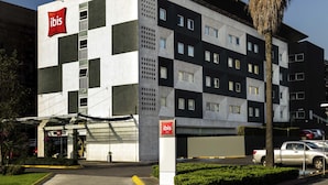 A modern hotel building with a checkered facade, multiple balconies, and a prominent 'ibis' sign. - ibis Mexico Perinorte (Cuautitlan Izcalli)
