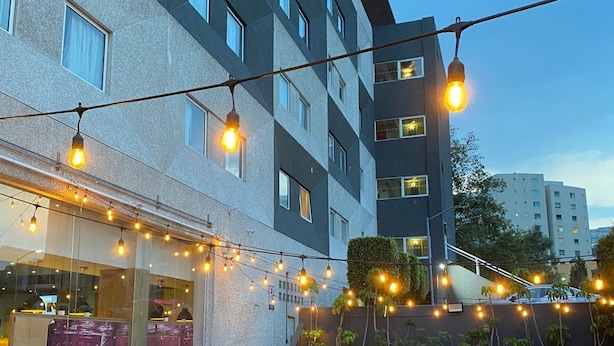 An outdoor patio with string lights, wooden tables, and chairs. - ibis Mexico Perinorte (Cuautitlan Izcalli)