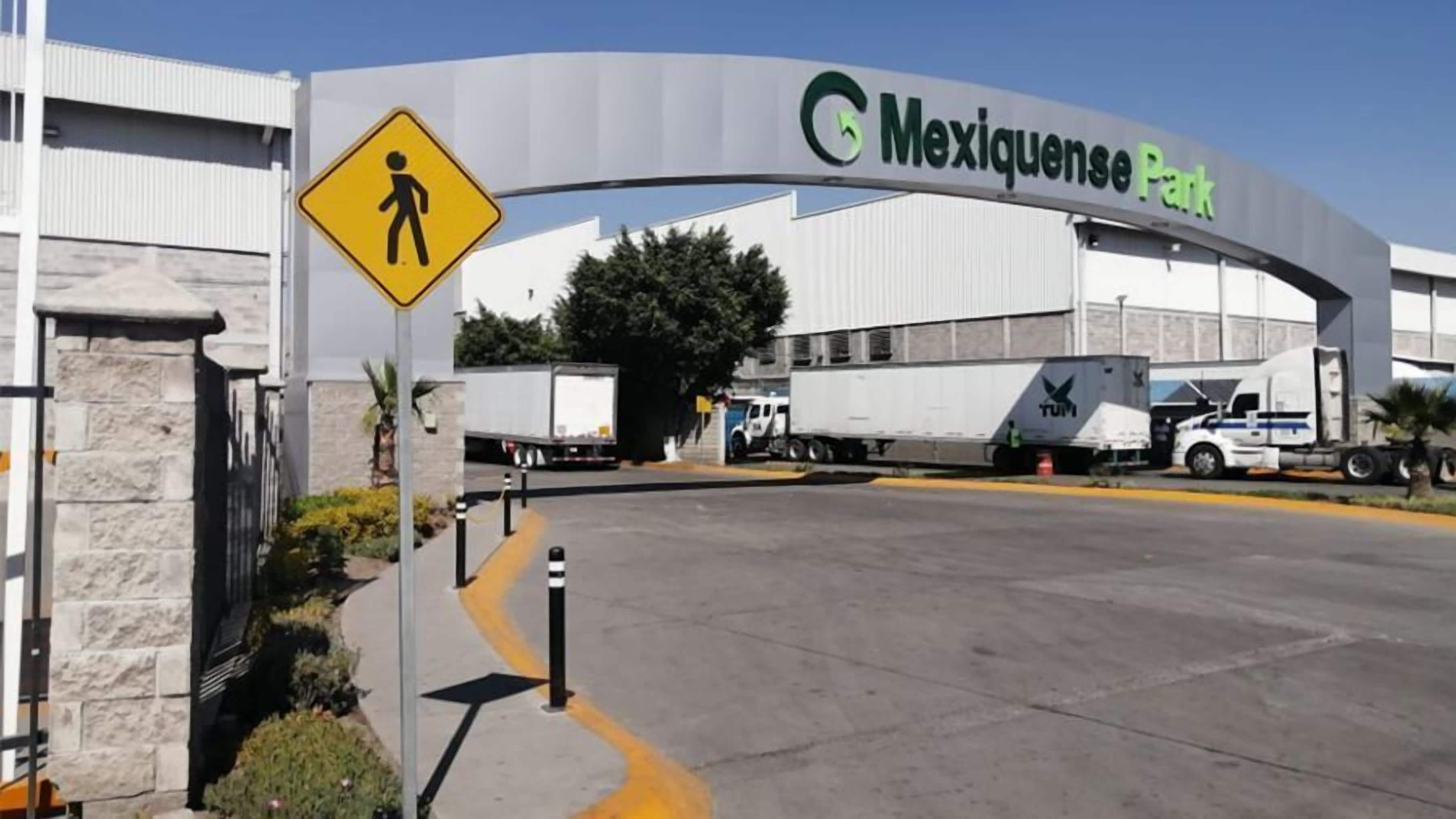 A large building with a sign reading 'Mexiquense Park' and a pedestrian crossing sign.