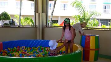 A colorful indoor play area with a ball pit and inflatable structures.