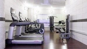 Une salle de sport équipée de tapis de course, de vélos elliptiques et de matériel de musculation.
