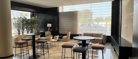 Un área de descanso moderna con un sofá, sillones y una mesa redonda.