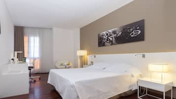 Relax in a serene space with a neatly made bed, bedside table, and abstract art above.