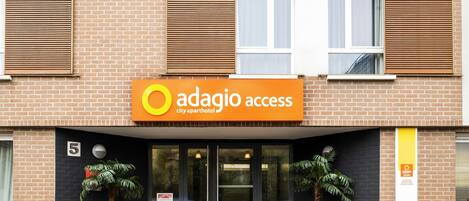 Un edificio con un cartel que dice 'adagio access city apartment hotel'.