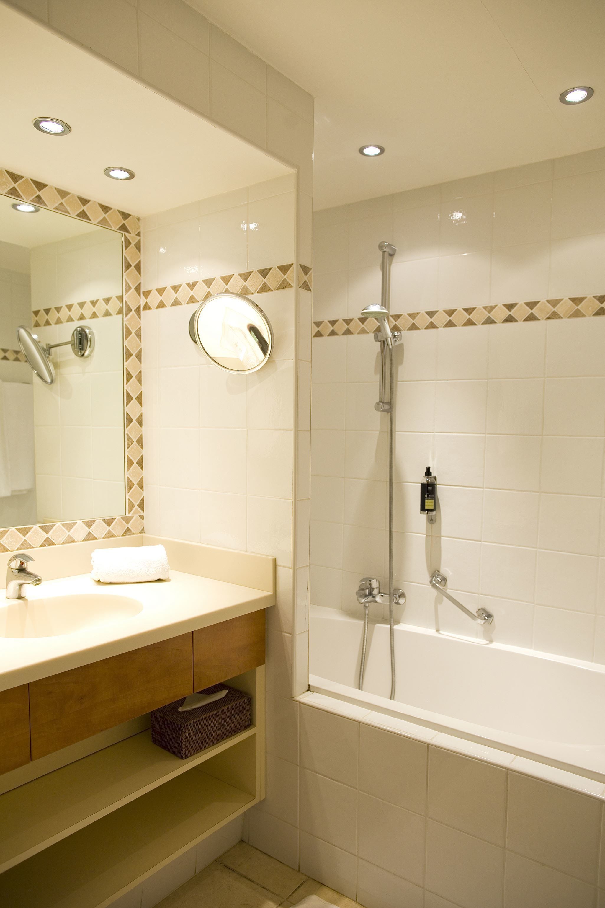 A bathroom with a sink, mirror, and shower.