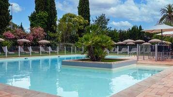 Alberca al aire libre por temporada y sombrillas en la alberca