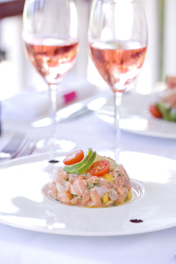 A seafood dish on a white plate with a fork and knife beside it.